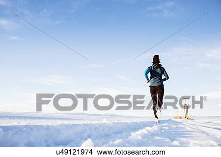 Rear view of mature woman running in snow View Large Photo Image Picture - Rear view of mature woman running in snow. Fotosearch