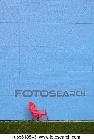 Stock Image - Red chair by blue wall. Fotosearch