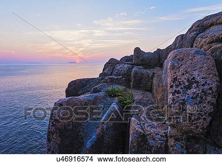 Rocky cliff by sea at sunrise View Large Photo Image Picture - Rocky cliff by sea at sunrise. Fotosearch