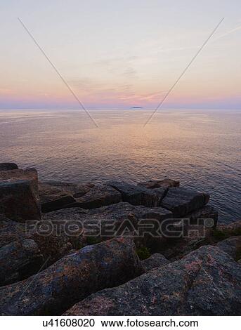 Rocky cliff by sea at sunrise View Large Photo Image Stock Image - Rocky cliff by sea at sunrise. Fotosearch