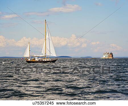 Sailboat in sea and Rockland Harbor Breakwater Lighthouse in distance View Large Photo Image Stock Photography - Sailboat in sea and Rockland Harbor Breakwater Lighthouse in distance. Fotosearch
