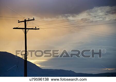 Silhouette of electricity pylon against cloudy sky View Large Photo Image Stock Photo - Silhouette of electricity pylon against cloudy sky. Fotosearch