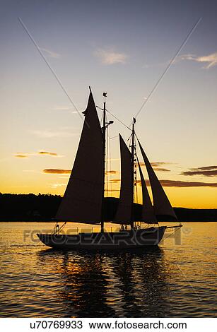 Silhouette of sailboat against sunset sky View Large Photo Image Stock Image - Silhouette of sailboat against sunset sky. Fotosearch