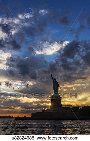 Stock Photo - Silhouette of Statue of Liberty at sunset. Fotosearch