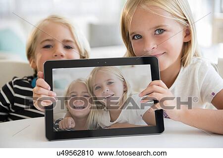Sister (6-7) and brother (5-6) showing picture on digital tablet View Large Photo Image Stock Image - Sister (6-7) and brother (5-6) showing picture on digital tablet. Fotosearch