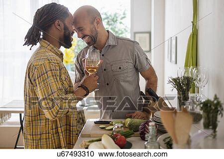 Smiley homosexual couple drinking wine in kitchen View Large Photo Image Stock Image - Smiley homosexual couple drinking wine in kitchen. Fotosearch