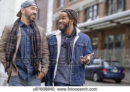 Smiley homosexual couple walking down street View Large Photo Image Stock Image - Smiley homosexual couple walking down street. Fotosearch