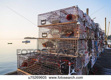 Stock Photography - Stacks of lobster traps at sunrise. Fotosearch