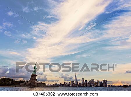 Stock Image - Statue of Liberty and financial district at dusk. Fotosearch
