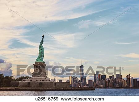 Stock Photo - Statue of Liberty and financial district at dusk. Fotosearch
