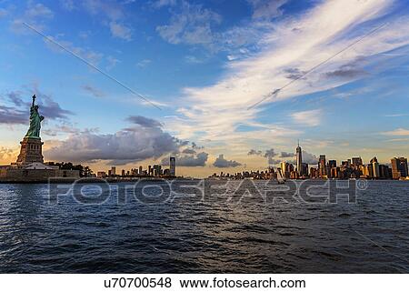 Statue of Liberty and financial district at dusk View Large Photo Image Stock Photo - Statue of Liberty and financial district at dusk. Fotosearch