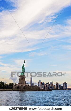 Statue of Liberty and financial district at dusk View Large Photo Image Stock Photograph - Statue of Liberty and financial district at dusk. Fotosearch