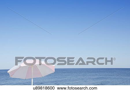 Stock Image - Sunshade against blue seascape. Fotosearch