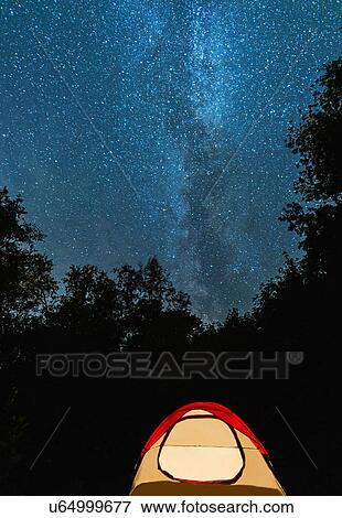 Stock Photo - Tent in forest against stars on night sky. Fotosearch