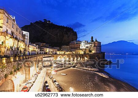 Stock Image - Town on coastline at dusk. Fotosearch