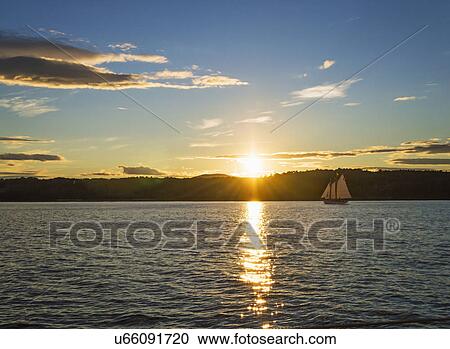 Tranquil seascape with sailboat at sunrise View Large Photo Image Stock Image - Tranquil seascape with sailboat at sunrise. Fotosearch