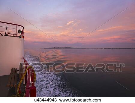 Stock Image - View from ferry towards sea at sunrise. Fotosearch