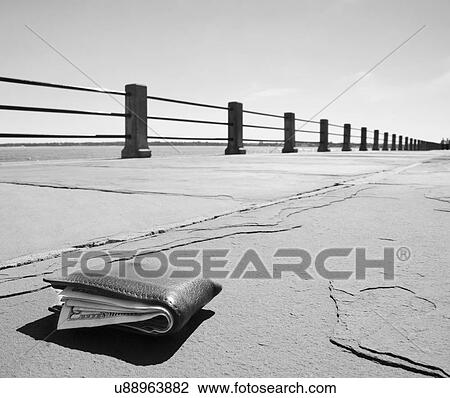 Stock Image - Wallet on empty promenade. Fotosearch