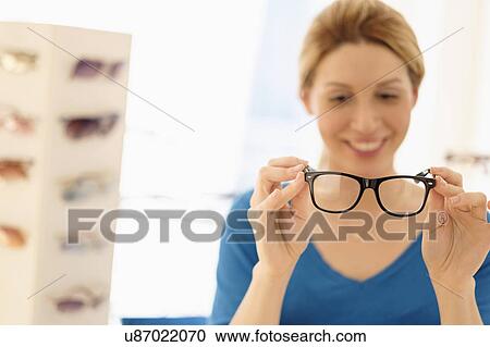 Woman and choosing eyeglasses in store View Large Photo Image Stock Image - Woman and choosing eyeglasses in store. Fotosearch
