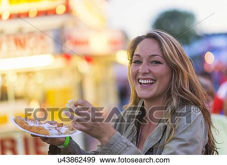 Woman eating funnel cake at funfair View Large Photo Image Stock Photo - Woman eating funnel cake at funfair. Fotosearch