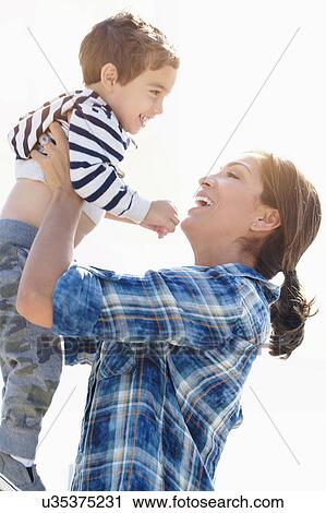 Stock Image - Woman playing with son (2-3). Fotosearch
