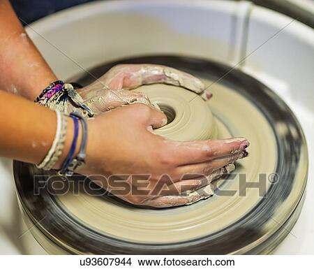 Picture - Woman shaping clay bowl on pottery wheel. Fotosearch