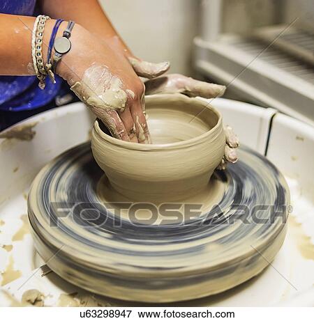 Stock Photo - Woman shaping clay bowl on pottery wheel. Fotosearch