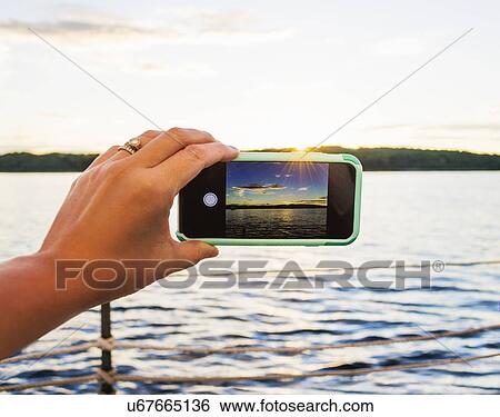 Woman taking picture with smartphone View Large Photo Image Stock Photograph - Woman taking picture with smartphone. Fotosearch