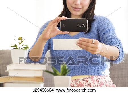 Young woman photographing bank statement View Large Photo Image Picture - Young woman photographing bank statement. Fotosearch