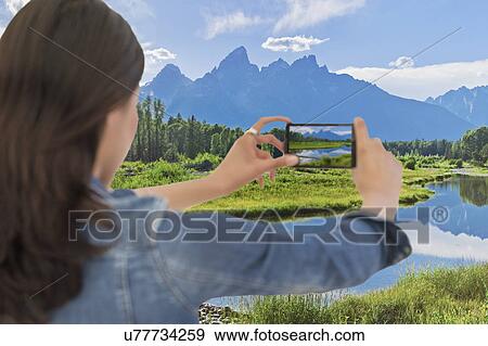 Young woman photographing mountain range View Large Photo Image Stock Photo - Young woman photographing mountain range. Fotosearch