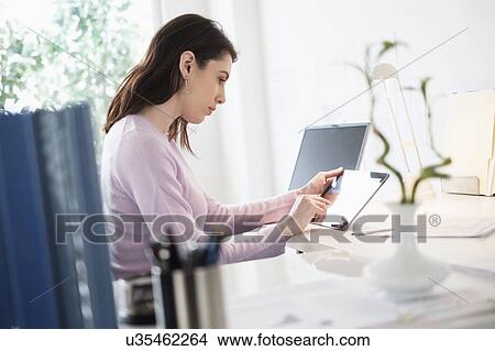 Picture - Young woman using digital tablet. Fotosearch