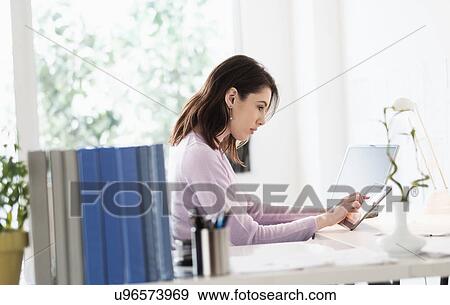 Stock Photo - Young woman using digital tablet. Fotosearch