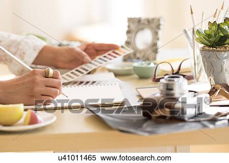 Stock Photography - Young woman writing in note pad. Fotosearch