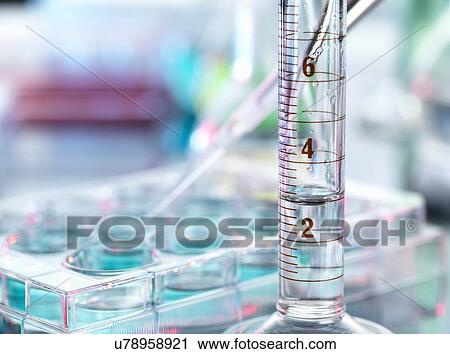Stock Image - A close up of a volumetric cylinder containing a chemical formula in a laboratory. Fotosearch