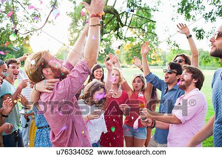 Adult crowd celebrating with arms raised at sunset party in park View Large Photo Image Stock Image - Adult crowd celebrating with arms raised at sunset party in park. Fotosearch