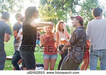 Adult friends dancing at park party at sunset View Large Photo Image Stock Image - Adult friends dancing at park party at sunset. Fotosearch