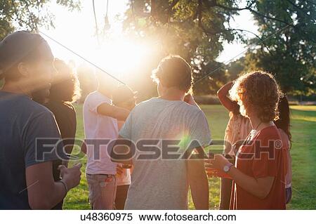 Adult friends partying and drinking in park at sunset View Large Photo Image Stock Photography - Adult friends partying and drinking in park at sunset. Fotosearch