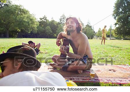 Adult friends playing acoustic guitar at sunset park party View Large Photo Image Stock Image - Adult friends playing acoustic guitar at sunset park party. Fotosearch