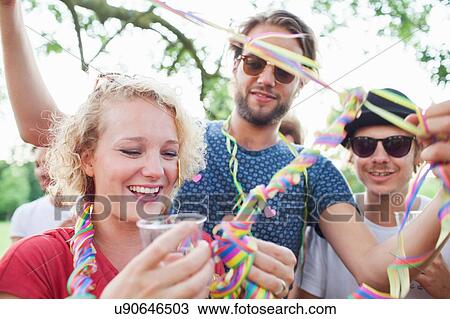 Adult friends wrapping each other in streamers at sunset party in park View Large Photo Image Stock Image - Adult friends wrapping each other in streamers at sunset party in park. Fotosearch