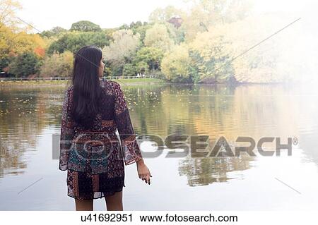 Back view of woman looking out at lake, Hampstead Heath, London View Large Photo Image Stock Image - Back view of woman looking out at lake, Hampstead Heath, London. Fotosearch