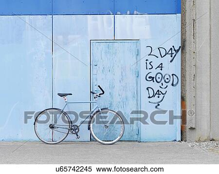 Stock Photography - Bicycle parked against graffiti wall. Fotosearch
