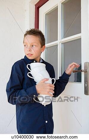 Boy carrying stack of cups on patio View Large Photo Image Stock Image - Boy carrying stack of cups on patio. Fotosearch