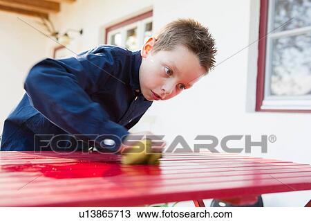 Boy concentrating on cleaning patio table View Large Photo Image Stock Image - Boy concentrating on cleaning patio table. Fotosearch
