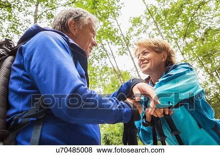 Couple in forest, face to face, smiling, low angle view View Large Photo Image Stock Photo - Couple in forest, face to face, smiling, low angle view. Fotosearch