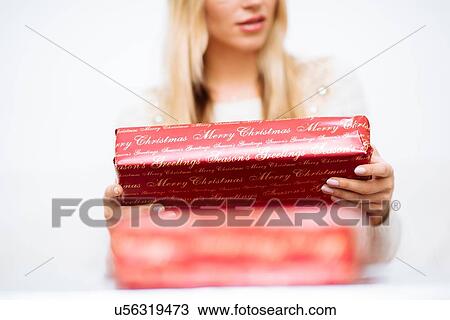 Cropped shot of young woman holding christmas present View Large Photo Image Stock Image - Cropped shot of young woman holding christmas present. Fotosearch