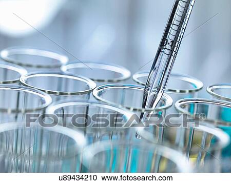 Stock Image - Cropped view of graduated pipette pipetting liquid into test tubes. Fotosearch