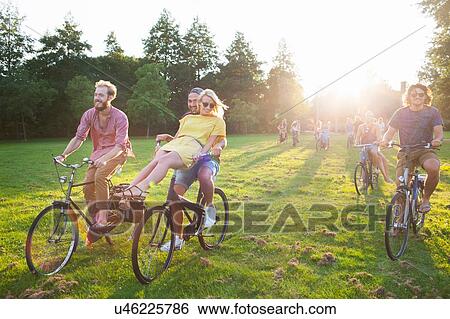 Crowd of partygoing adults arriving on bicycles to sunset park party View Large Photo Image Stock Photograph - Crowd of partygoing adults arriving on bicycles to sunset park party. Fotosearch