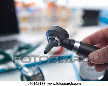 Doctor holding otoscope View Large Photo Image Stock Photo - Doctor holding otoscope. Fotosearch