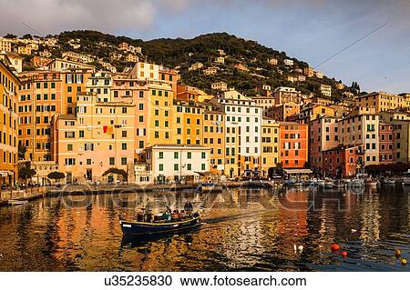 Stock Image - Elevated view of fishing boat leaving the harbor, Camogli, Liguria, Italy. Fotosearch