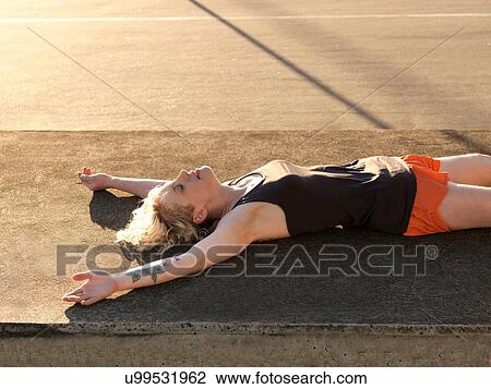 Exhausted young woman taking a training break in parking lot View Large Photo Image Stock Image - Exhausted young woman taking a training break in parking lot. Fotosearch